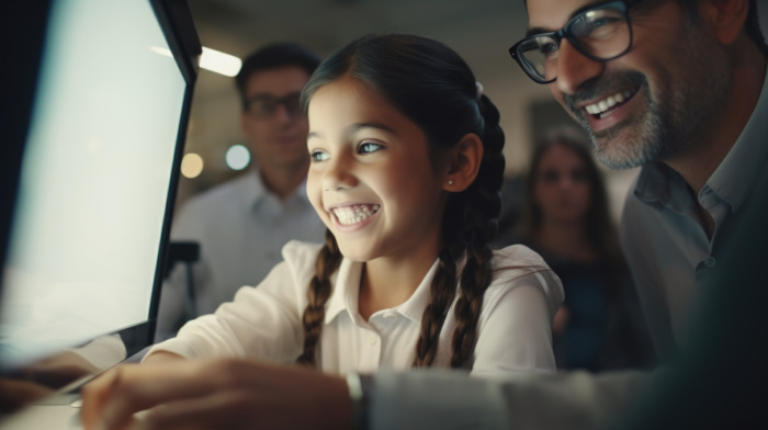 niña sonríe delante de una computadora