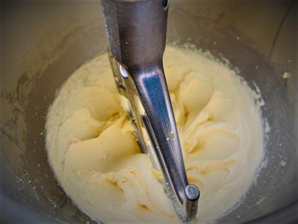 Se observa la paleta de la batidora cremando la mantequilla, margarina, yema de huevo y esencia. 
