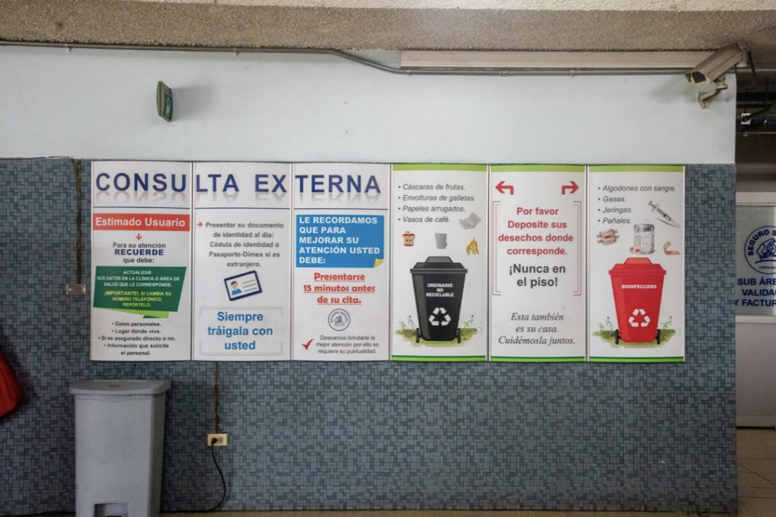 Fotografía de mural en hospital México, en el que parte del mismo son dos contenedores, uno rojo y otro negro, y cada uno acompañado por una lista de los residuos que van en cada uno. Y dice “por favor deposite sus desechos donde corresponde, nunca en el piso”